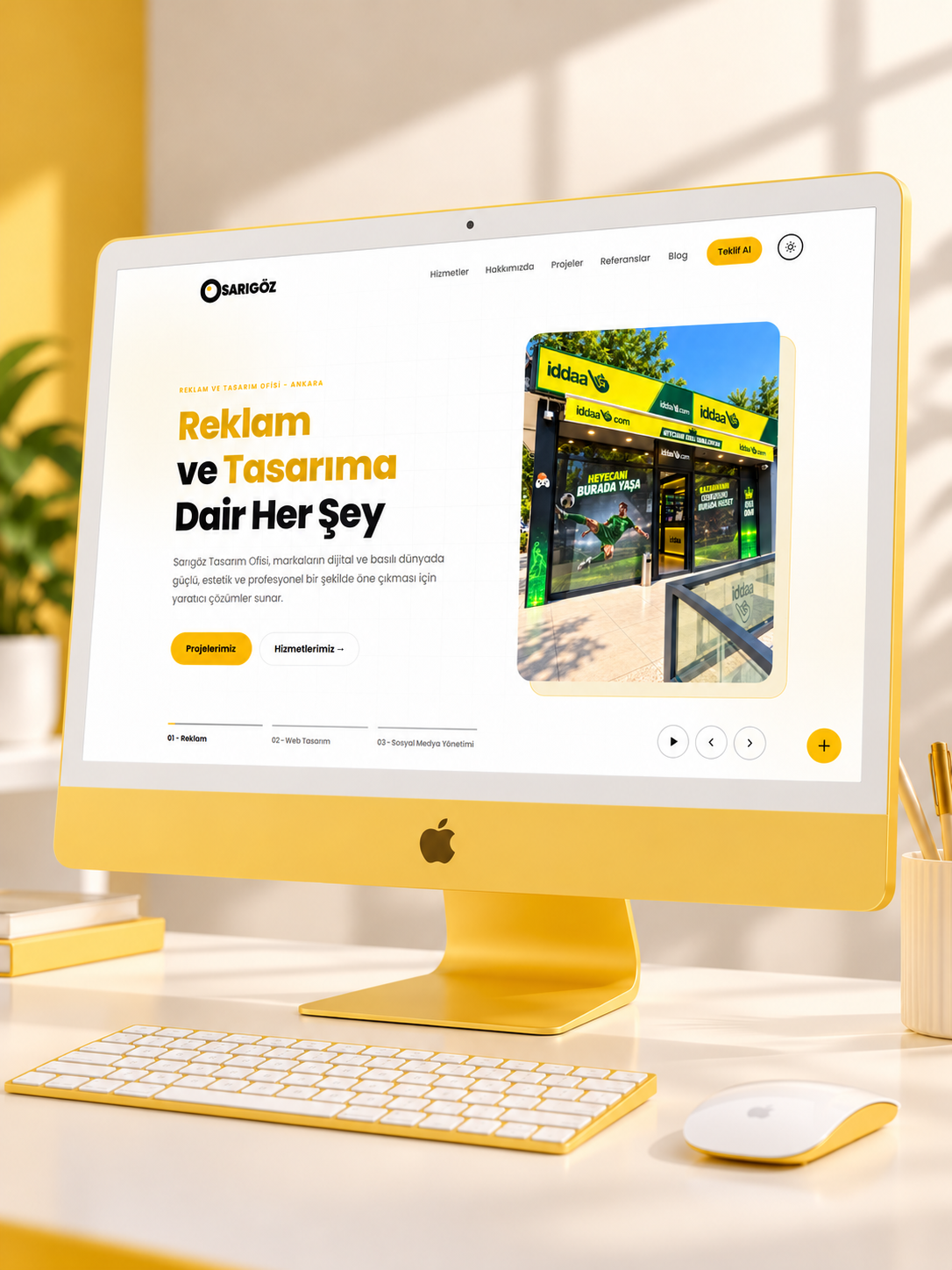Ekranında modern bir web sitesi tasarımı açık olan tasarımcı masası